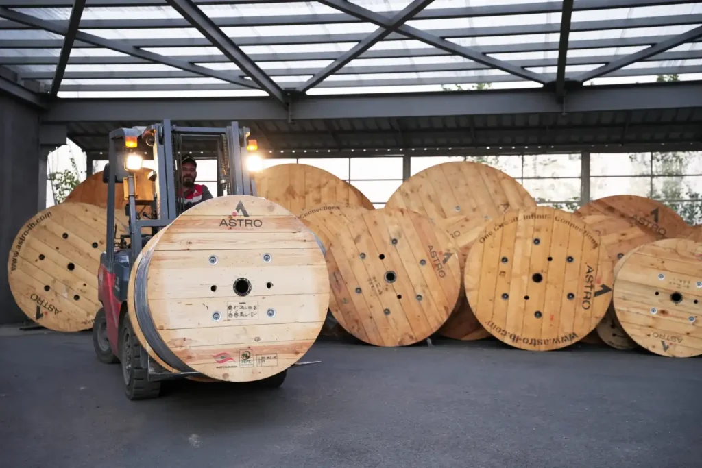 Forklift moving Astro Cables' large cable reels in the warehouse.