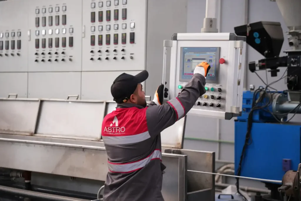 Worker controlling Astro Cables' production line extrusion machine.