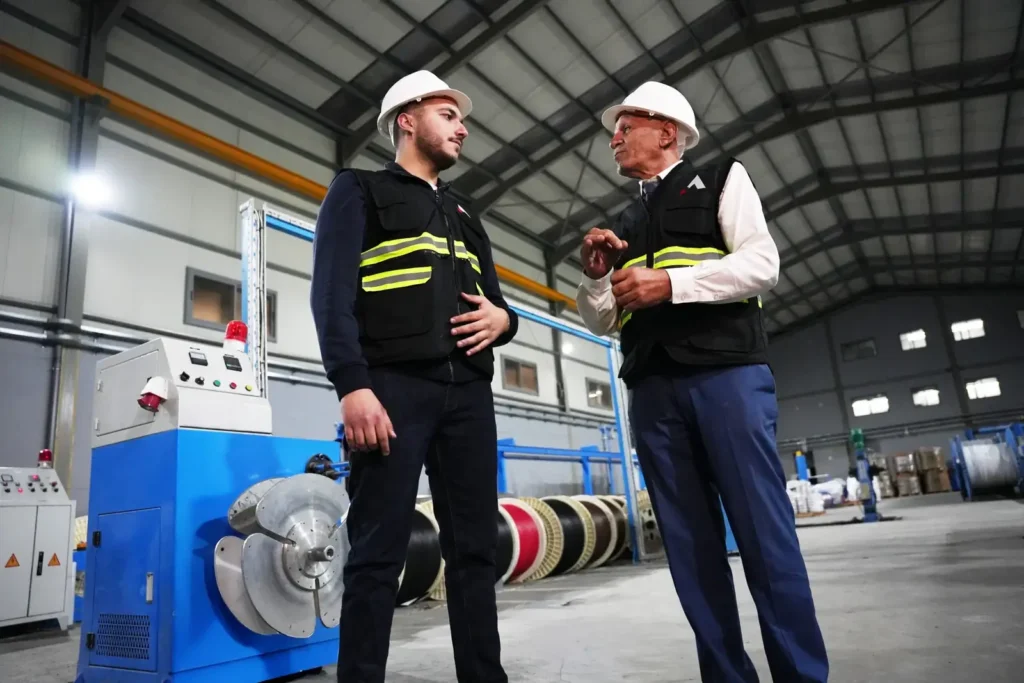 Astro Cables team discussing cable production process in factory.