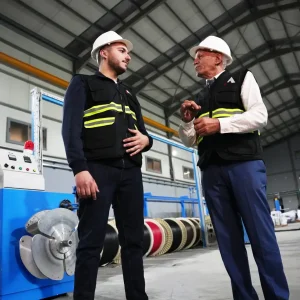 Astro Cables team discussing cable production process in factory.